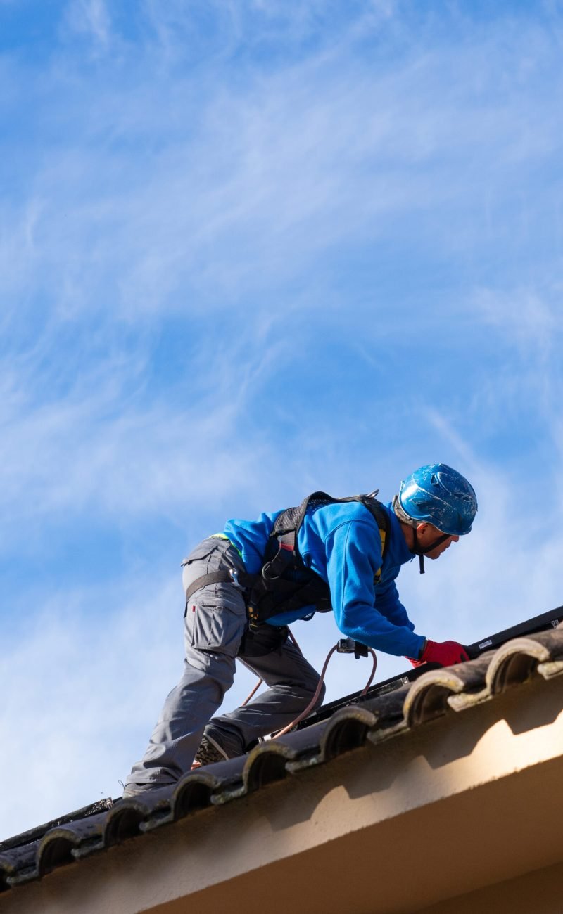 Solar panel installer working on a roof